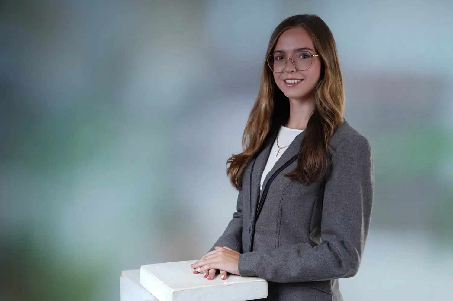Bewerbungsfoto einer jungen Frau im grauen Blazer im Freien, Querformat